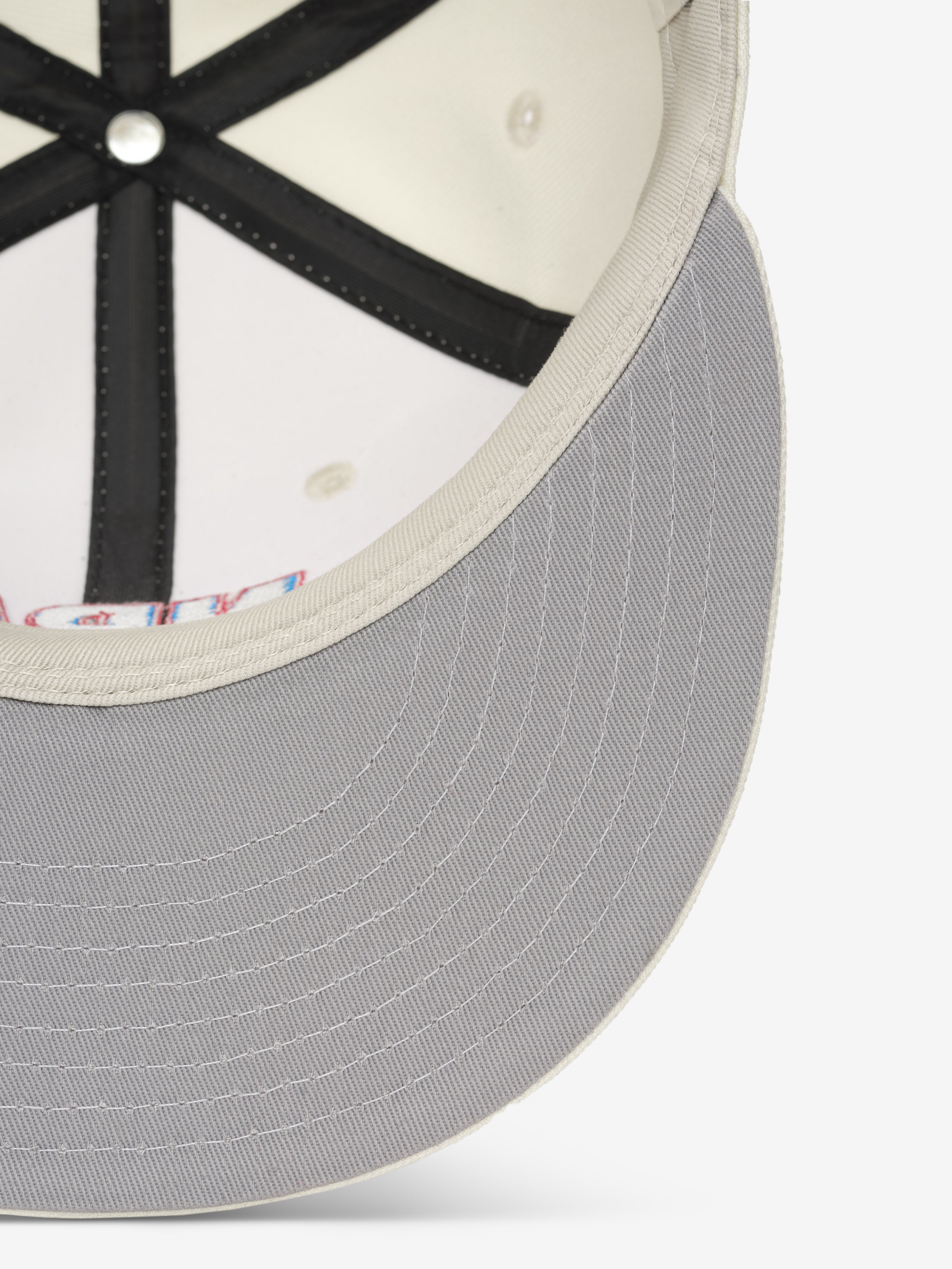 close-up of light gray cap brim with off-white stitched edge and black interior seams on snapback hat