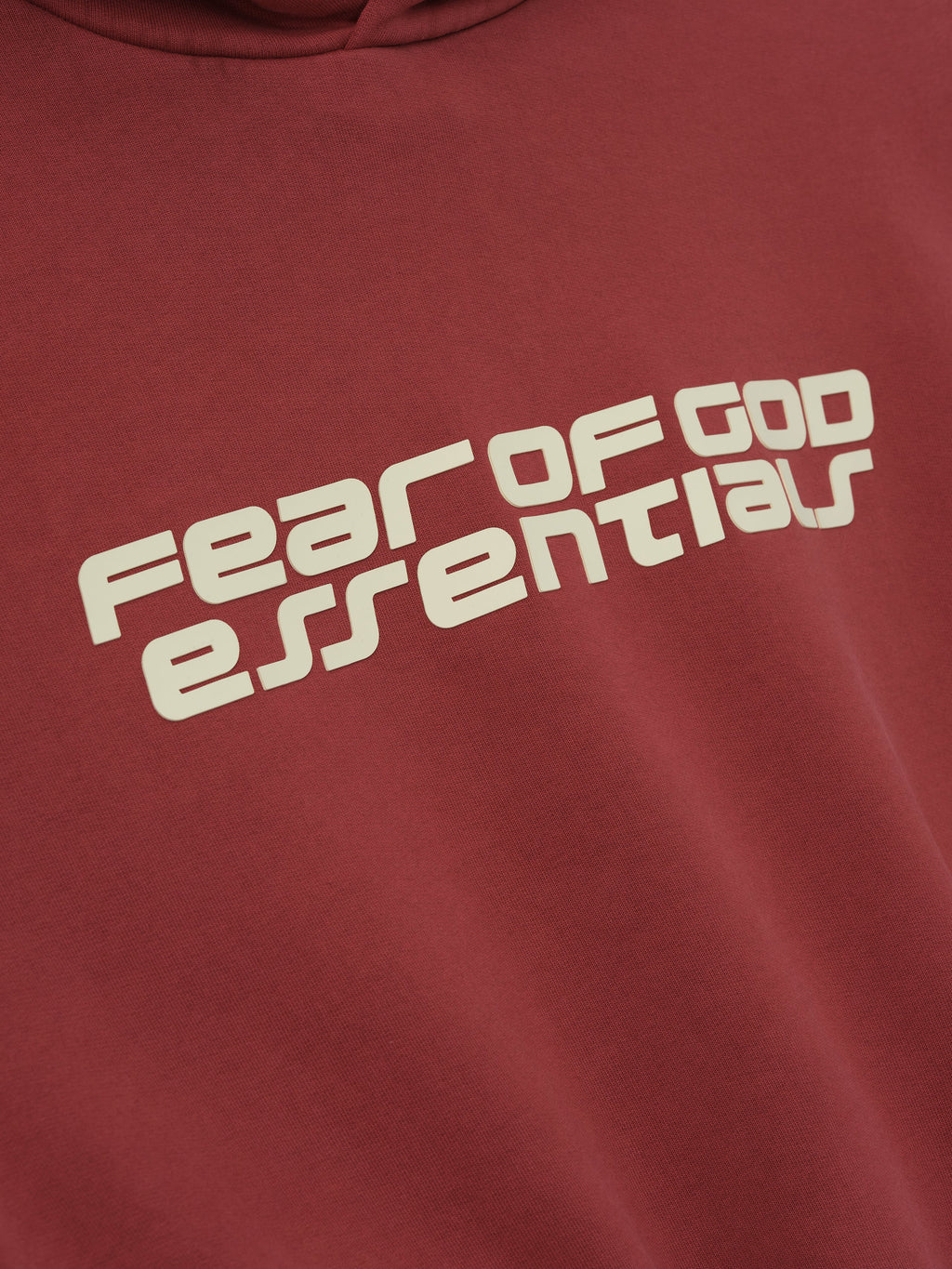 Close-up of crimson Kids Classic Hoodie showing angled Fear of God Essentials logo on chest, gallery position 0