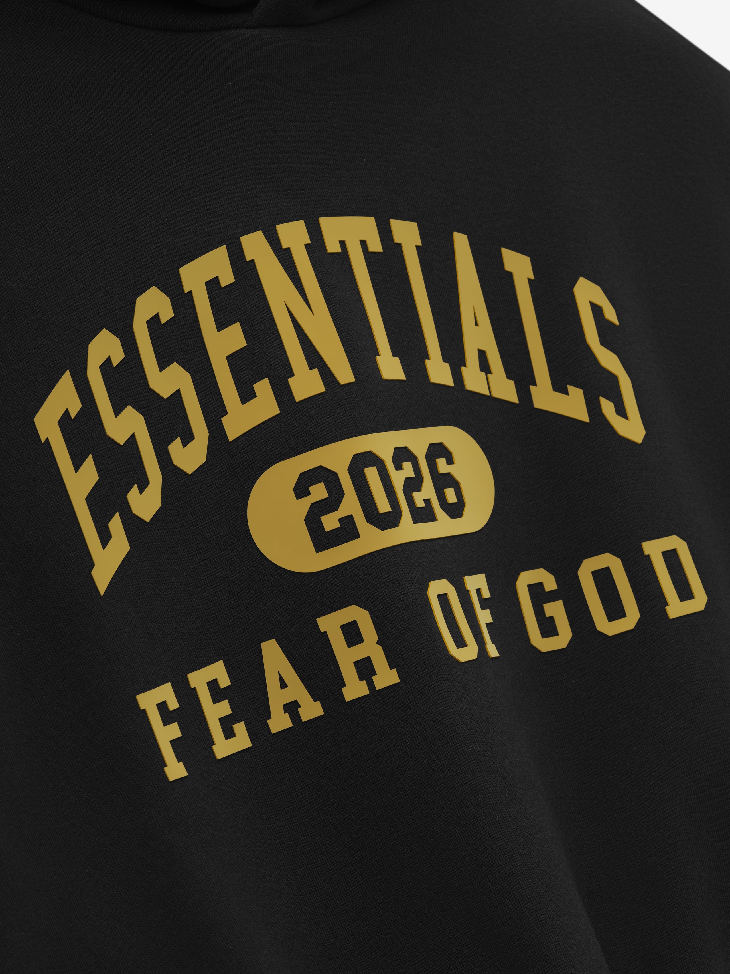 Close-up of vintage black Kids Classic Hoodie showing gold ESSENTIALS 2026 Fear of God logo on soft fabric, gallery position 0