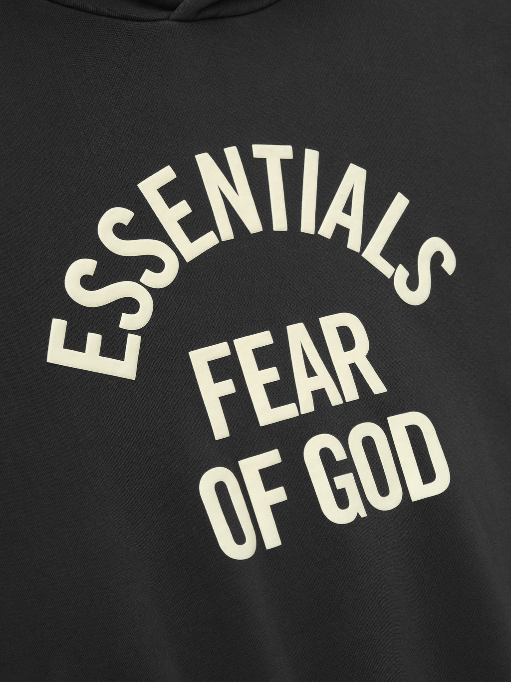 close-up of pigment-dyed black hoodie with off-white Essentials Fear of God text printed in arched style