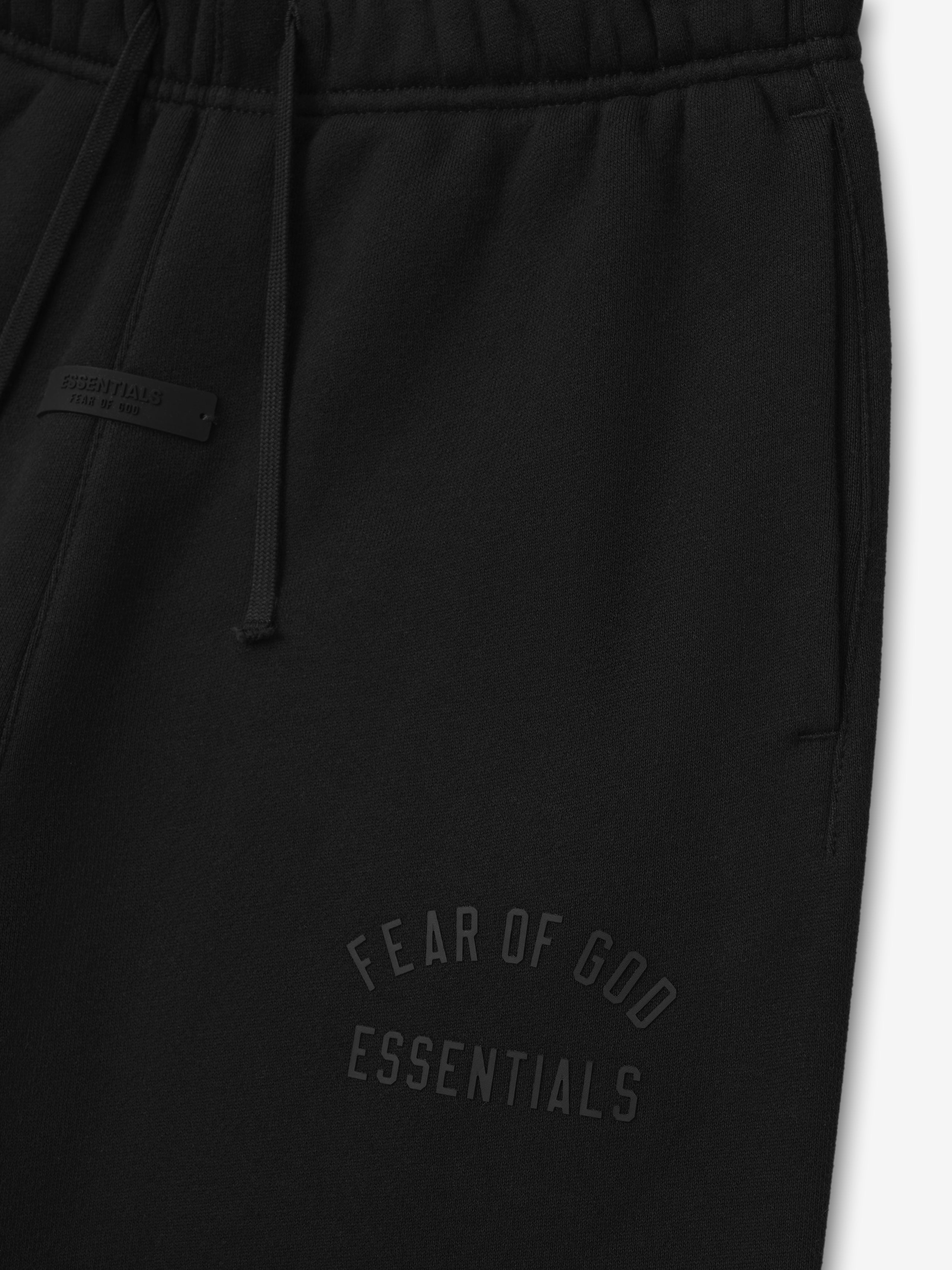 black kids sweatpants with elastic waistband and embossed Fear of God Essentials logo on tapered leg in fleece fabric