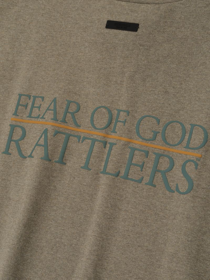 Close-up of brown FAMU 90s Tee fabric with green "FEAR OF GOD RATTLERS" text and thin orange underline, file 8Nfmc_ZQ.jpg