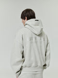 back view of light grey fleece hoodie with ESSENTIALS Fear of God logo and relaxed fit on male model