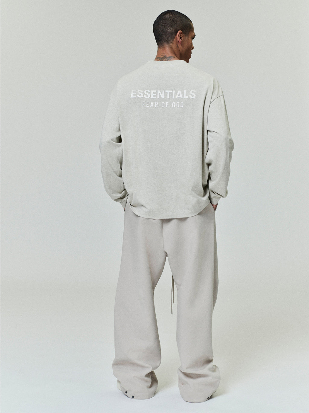 rear view of light gray medium-weight cotton long sleeve tee with ESSENTIALS Fear of God printed logo across upper back