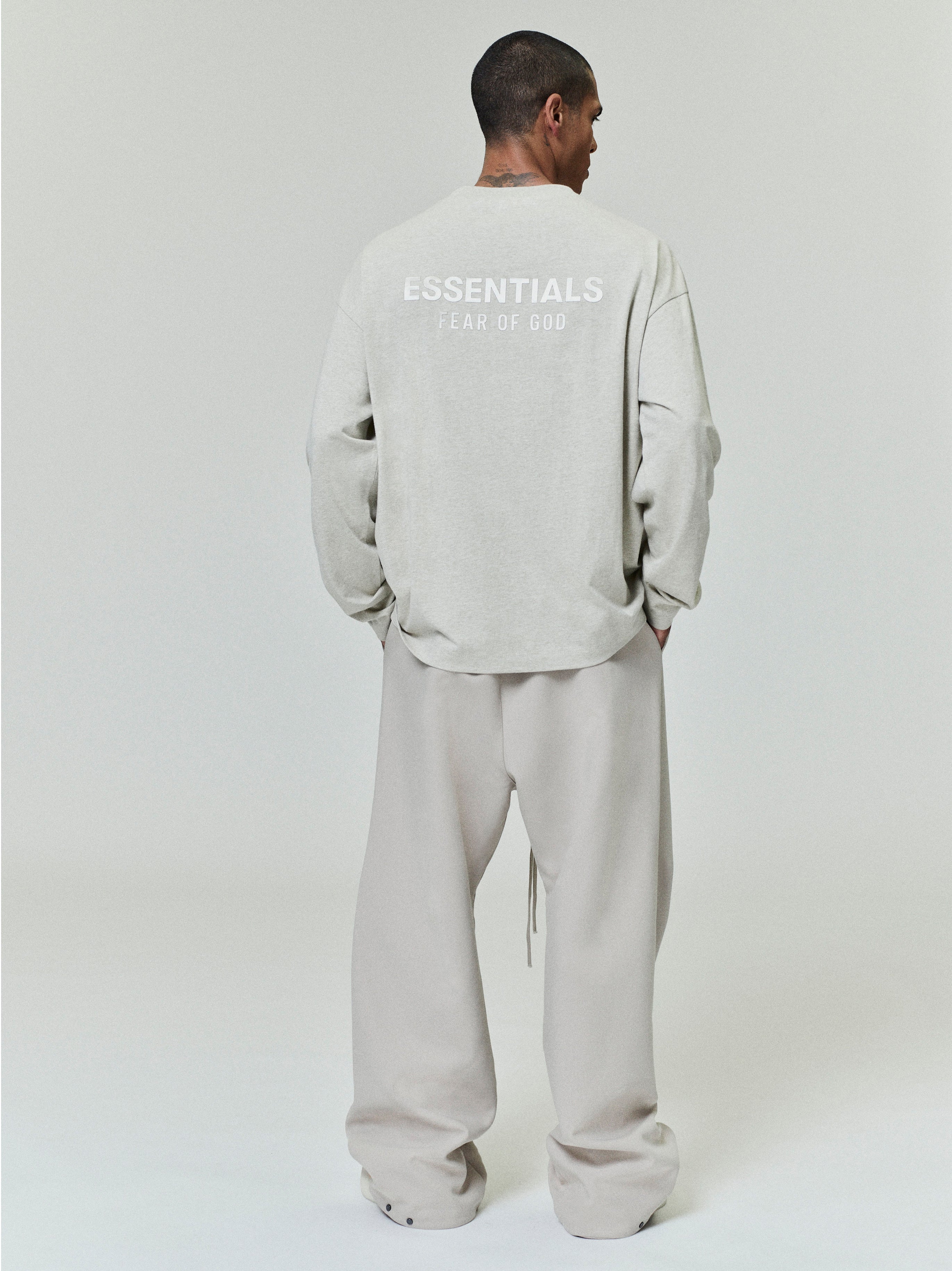 rear view of light gray medium-weight cotton long sleeve tee with ESSENTIALS Fear of God printed logo across upper back