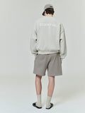 Rear view of model wearing light grey Classic Fleece Crewneck with ESSENTIALS logo paired with taupe shorts and matching cap