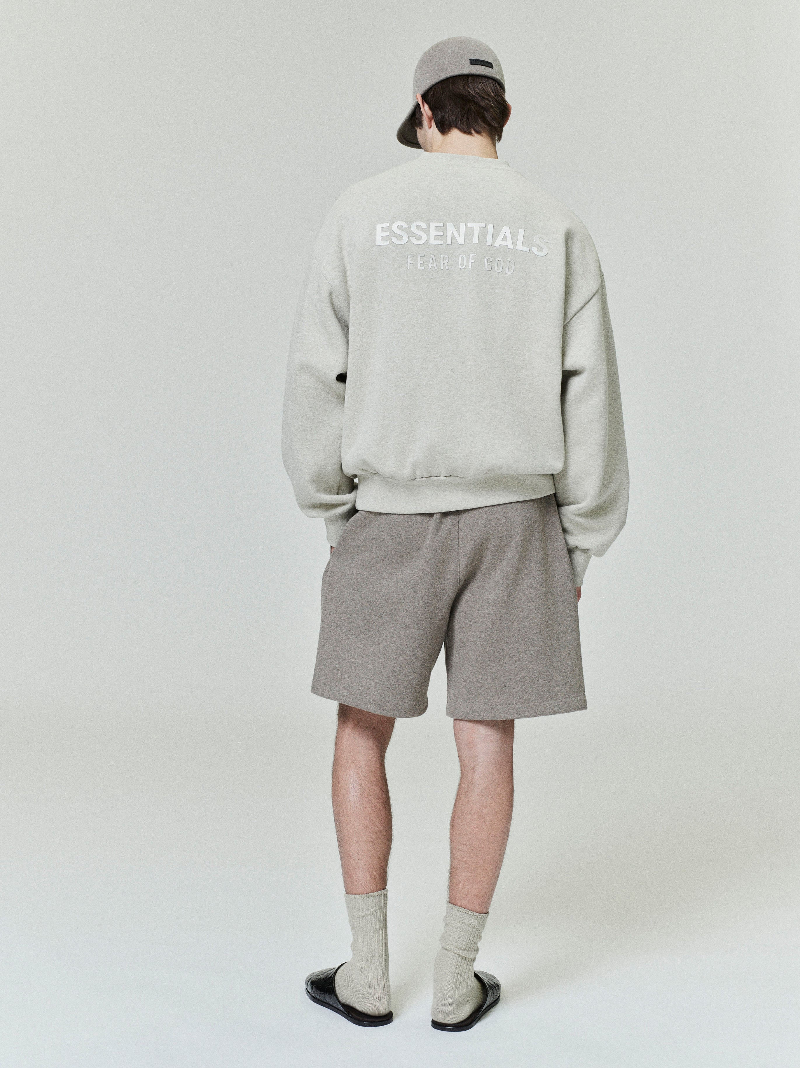 male model seen from behind wearing taupe classic fleece sweatshorts with relaxed fit and 90s-inspired mid-length leg