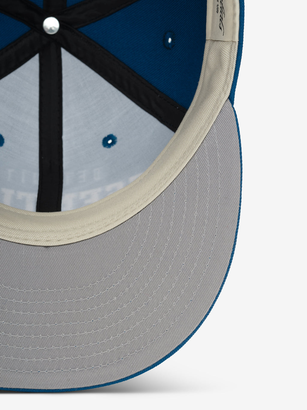 Close-up inside view of Lions 9Fifty RC Snapback showing gray underbill and beige inner sweatband detail, gallery image 0