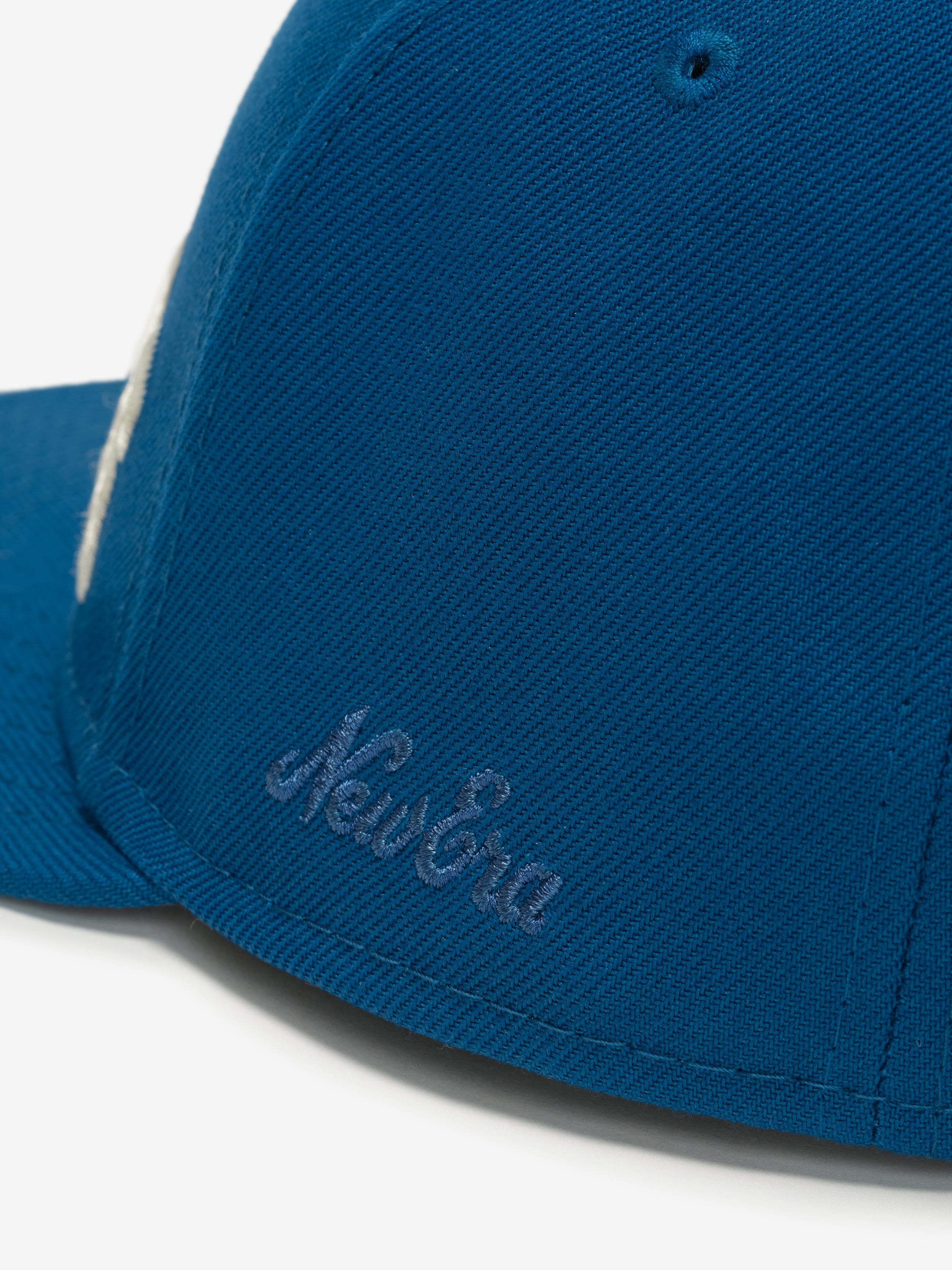 Close-up side view of blue Lions 9Fifty RC Snapback showing tonal New Era embroidery near the brim, gallery image 0