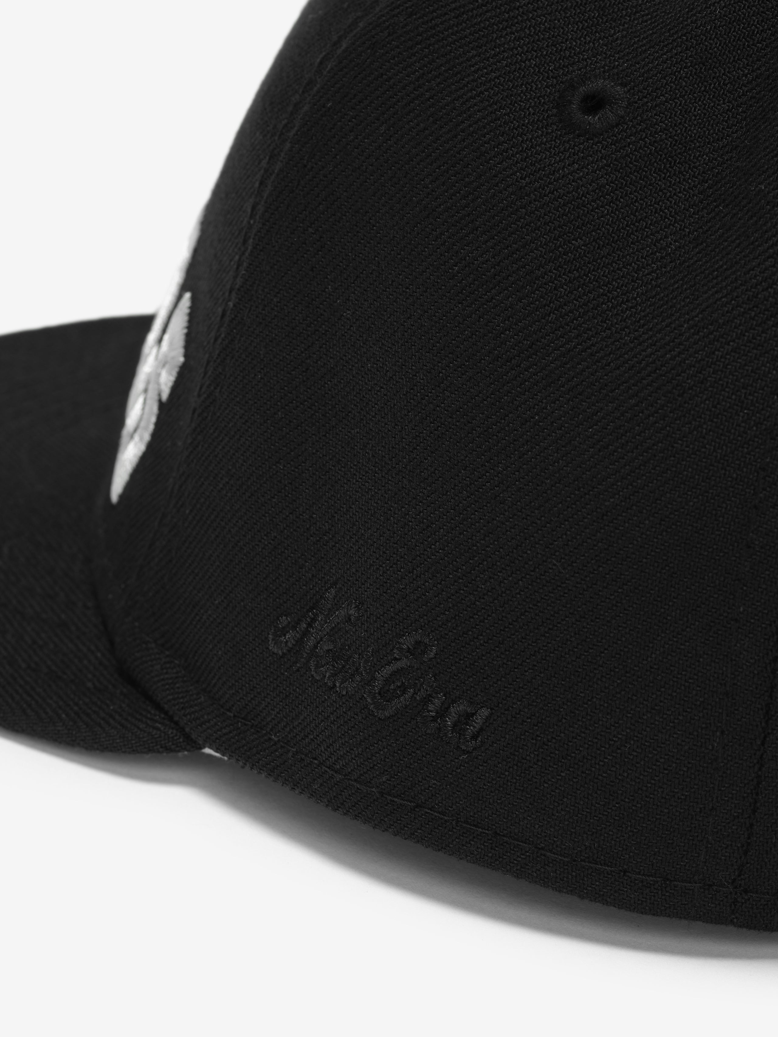 Close-up angled view of black Raiders 9Fifty RC Snapback showing subtle side embroidery detail, gallery image 0