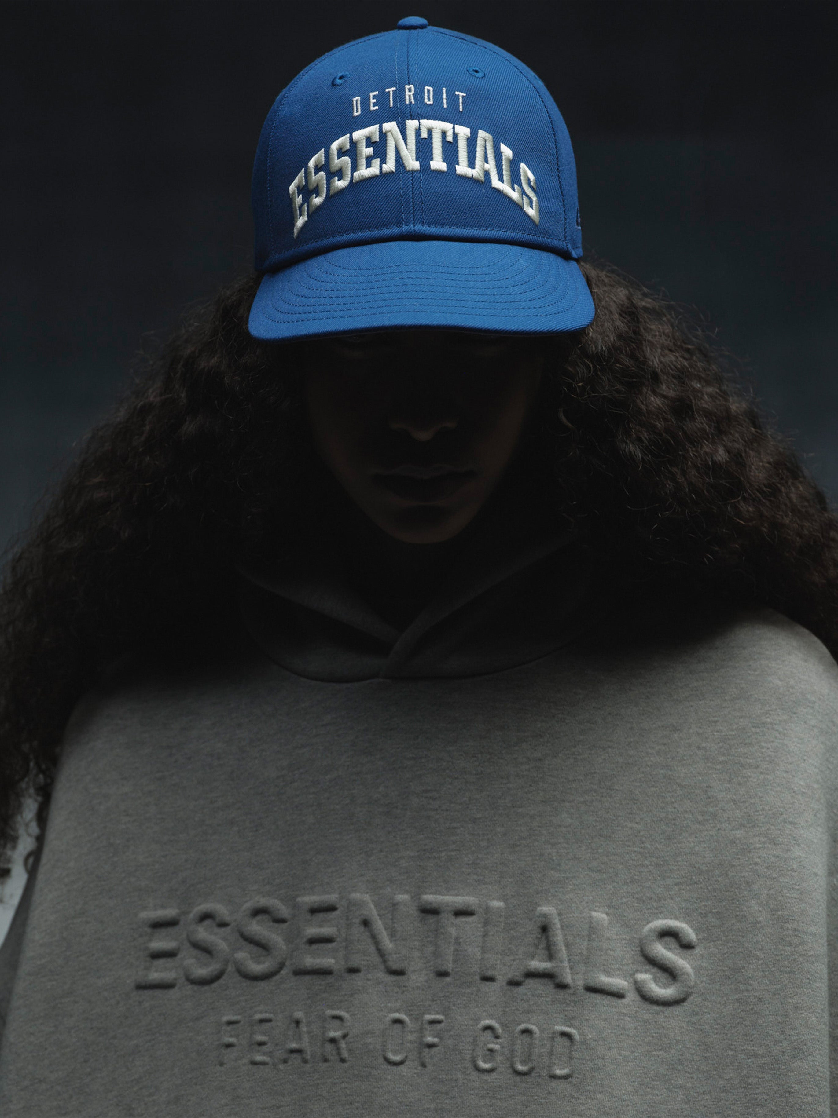 Front view of blue Lions 9Fifty RC Snapback with white Detroit Essentials embroidery, worn by model in shadow, IMAGE31.jpg gallery 0