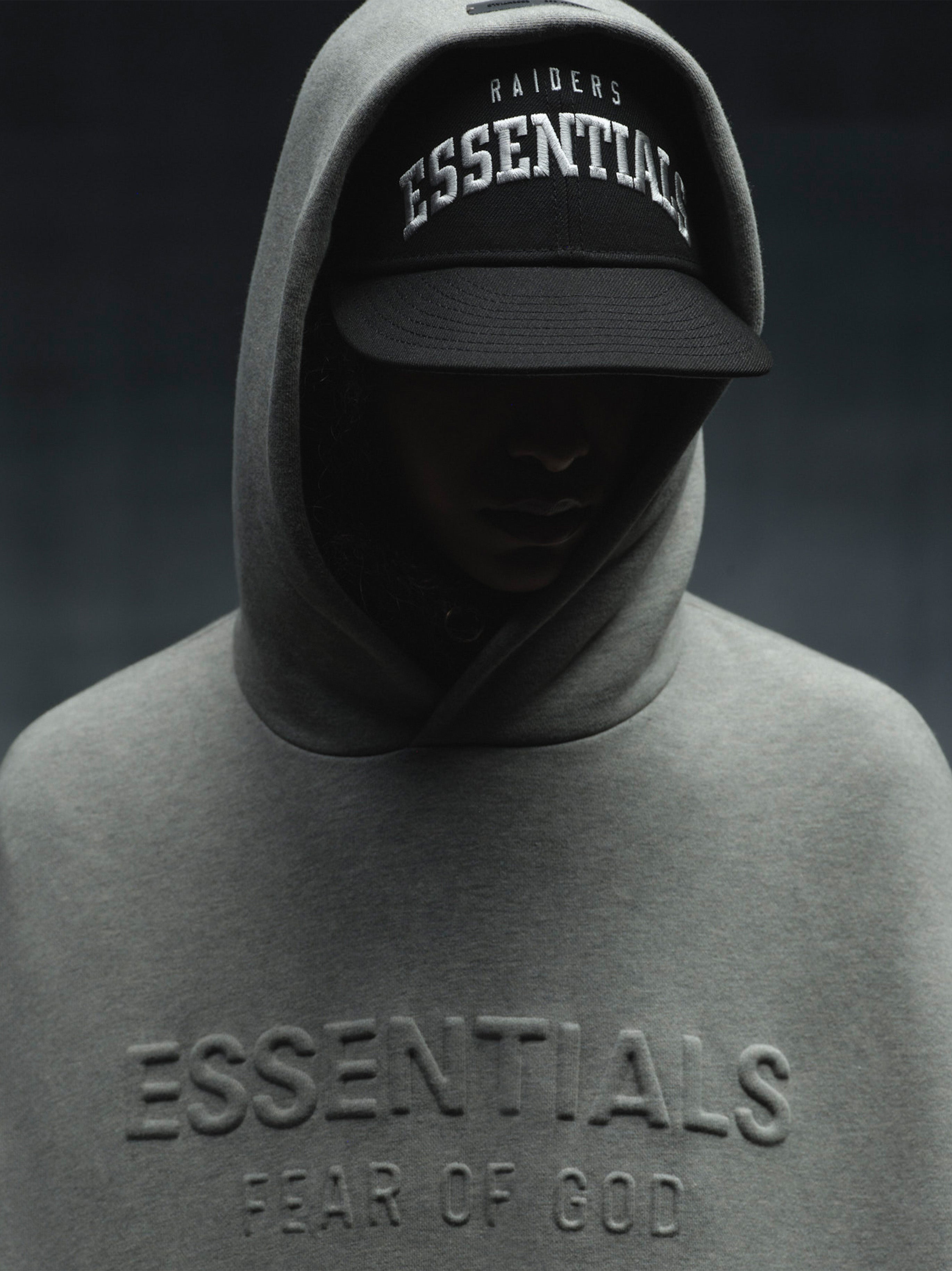 Front view of Raiders 9Fifty RC Snapback with bold "Essential" embroidery, worn under grey Essentials hoodie, gallery image 0