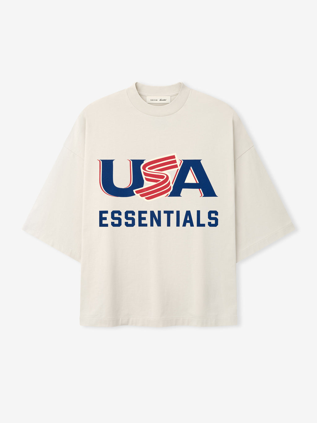 Cream oversized short-sleeve T-shirt with bold navy and red "USA ESSENTIALS" graphic on front center