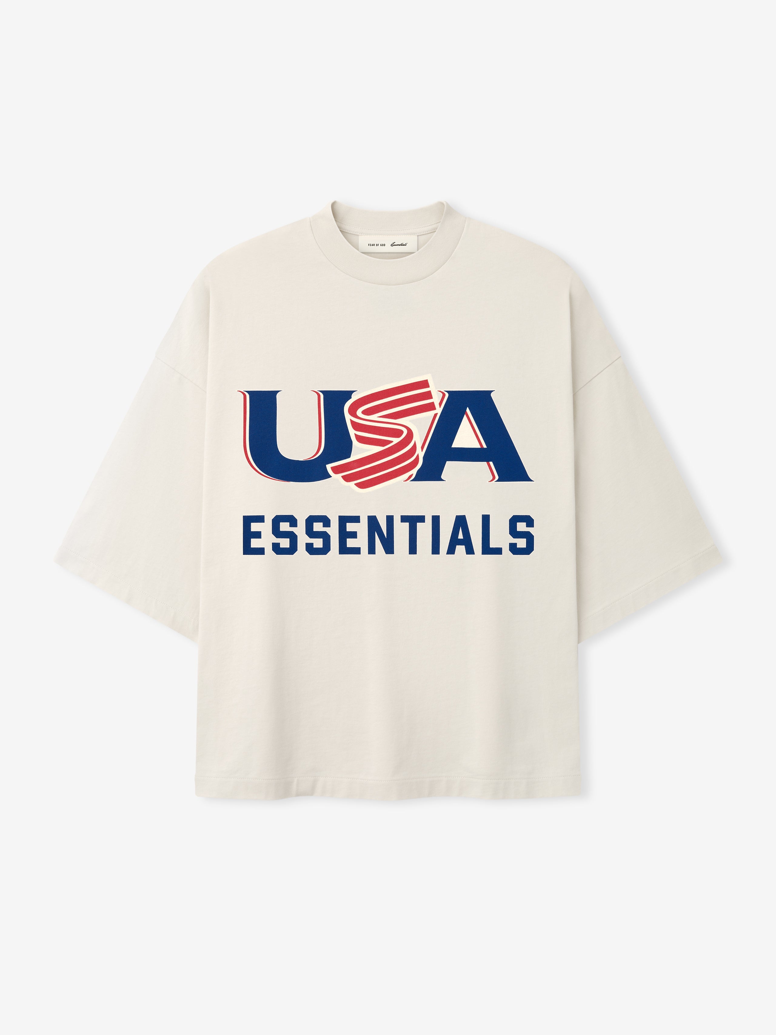 Cream oversized short-sleeve T-shirt with bold navy and red "USA ESSENTIALS" graphic on front center