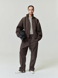 woman wearing brown relaxed straight-leg track pants with elastic waistband and front drawstring closure