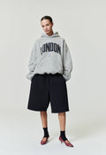 Model wearing grey London 90s Hoodie with black London text and small NBA logo, standing pose SP26_FW_L61-P_2895