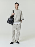 model wearing light beige relaxed fit sweatpants with drawstring waist and matching oversized quarter-zip pullover