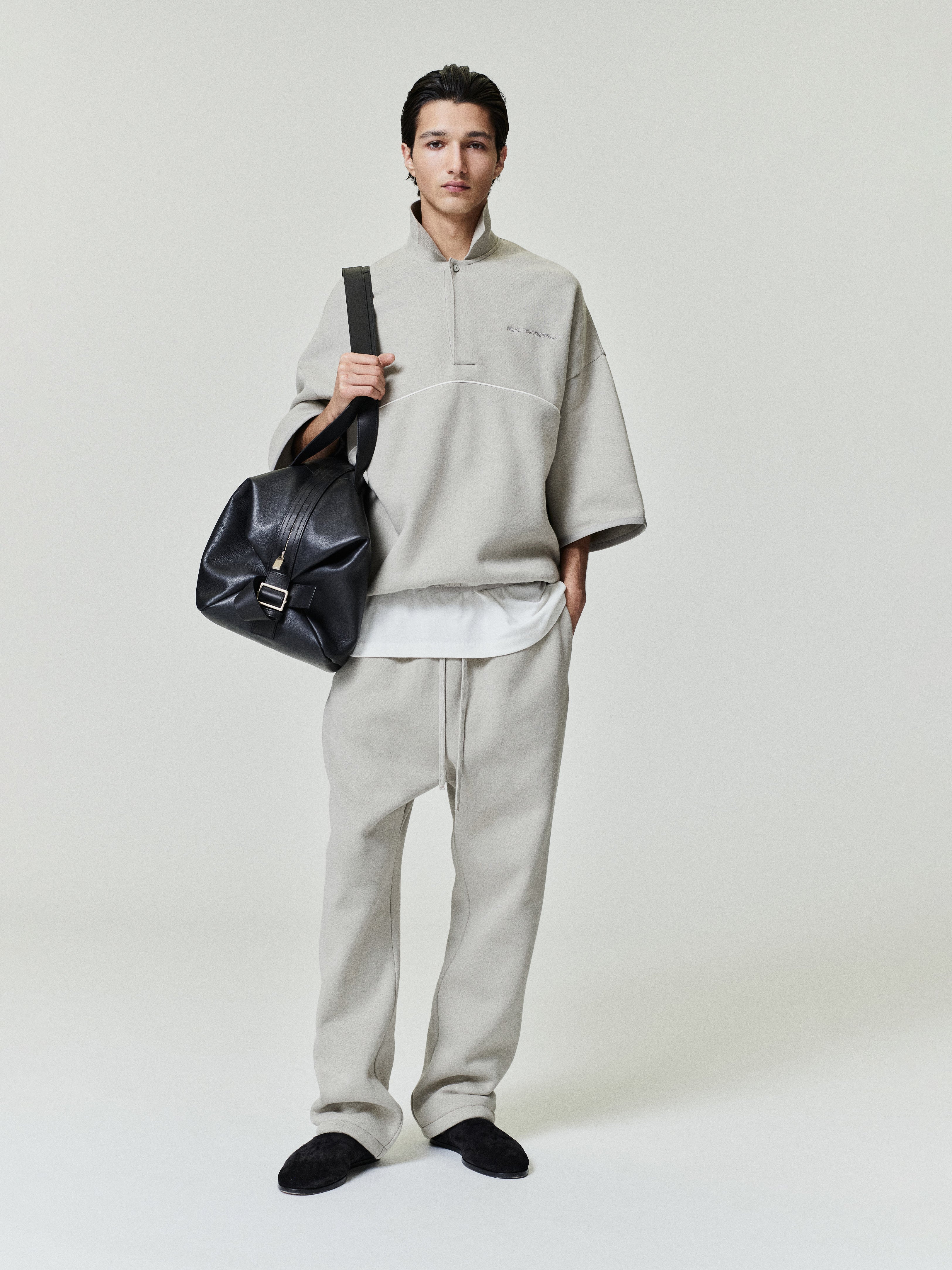 model wearing light beige relaxed fit sweatpants with drawstring waist and matching oversized quarter-zip pullover