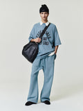 blue oversized 90s-style heavyweight cotton tee with ESSENTIALS FEAR OF GOD text, paired with matching relaxed pants