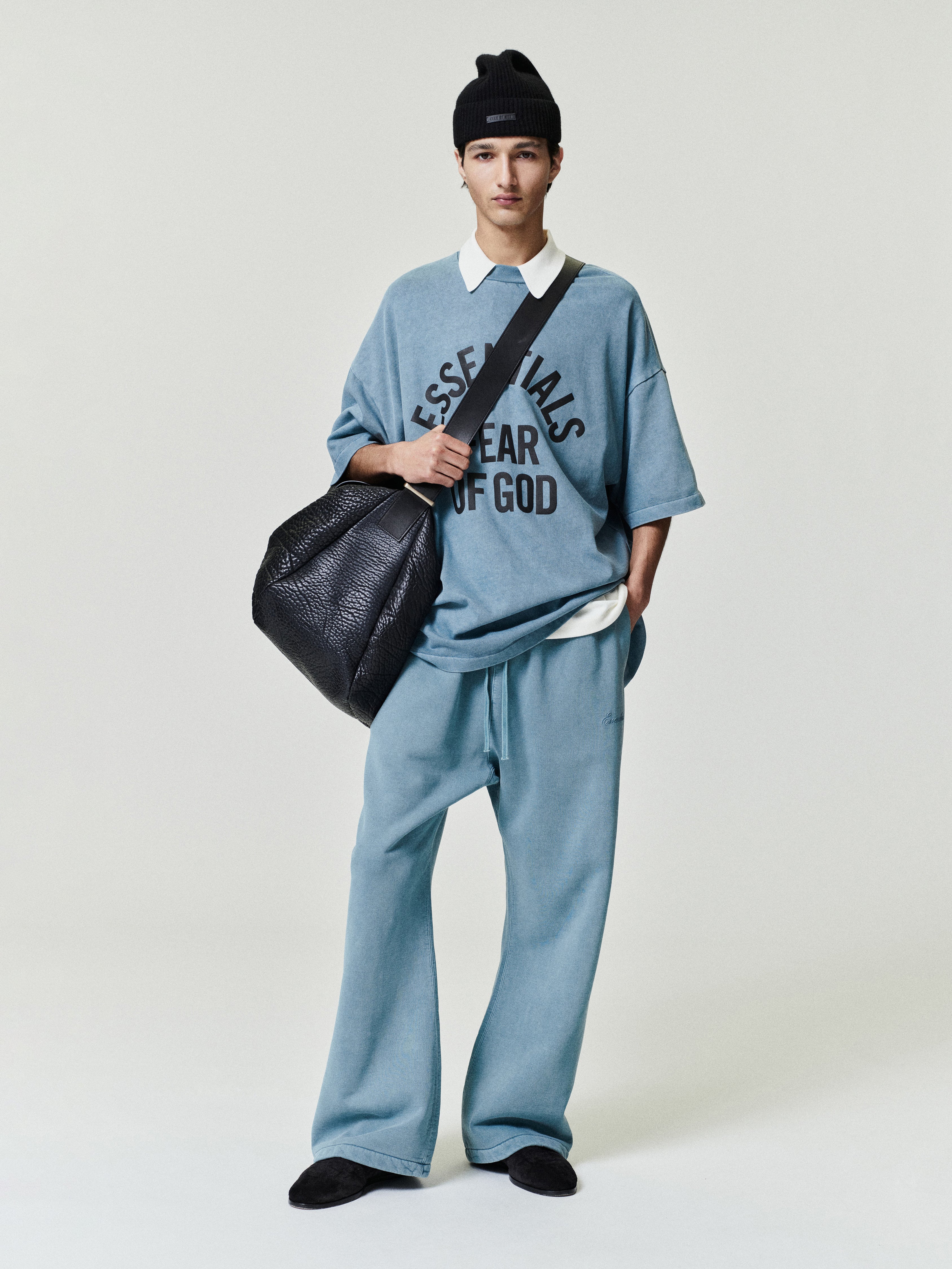 man wearing relaxed fit vintage blue fleece flare sweatpants with drawstring waistband and oversized t-shirt