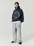 navy oversized hoodie with circular NBA Essentials text and basketball graphic worn with gray sweatpants with matching logo