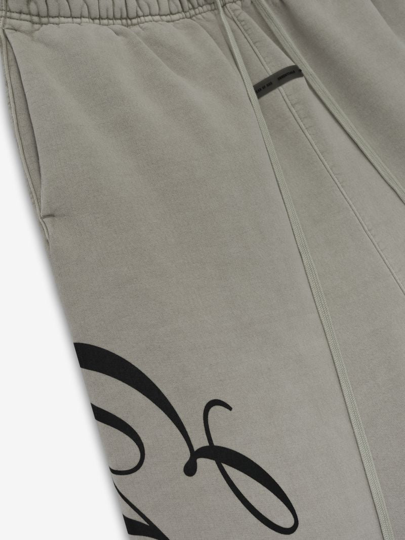Close-up of light taupe Heavy Fleece Lounge Sweatpant showing elastic waistband and partial black script detail, gallery 0