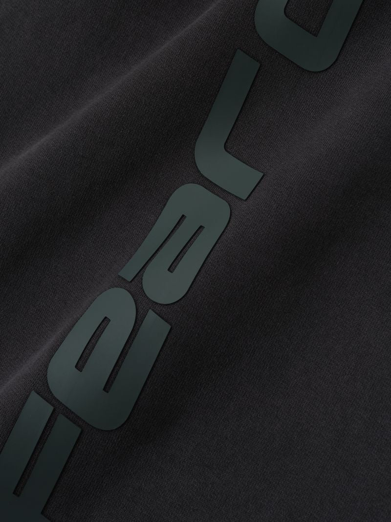 Close-up detail of black Heavy Fleece Flare Sweatpant showing embossed vertical script branding, gallery image 0, file uUZ62kBw.jpg